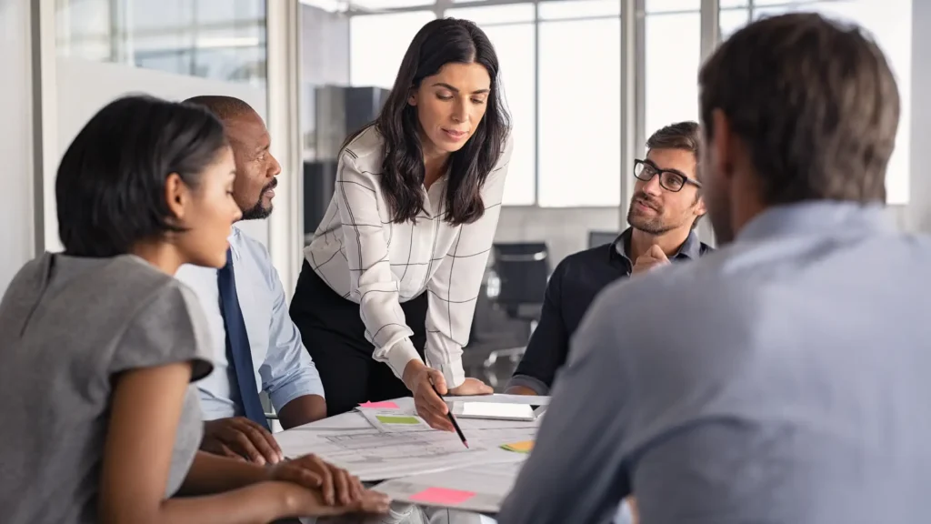 A group of people discussing a project in an office setting.